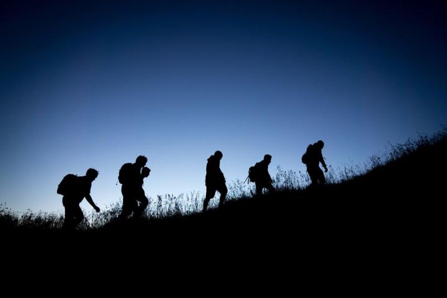 Group of people hiking up hill in the dark