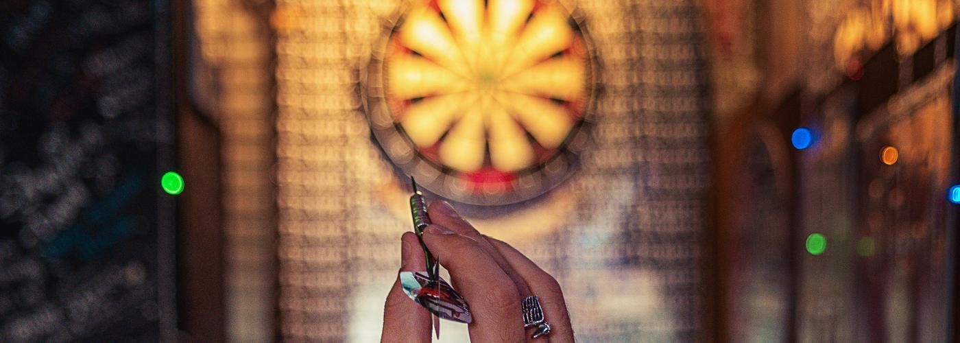 person preparing to throw a dart at the target