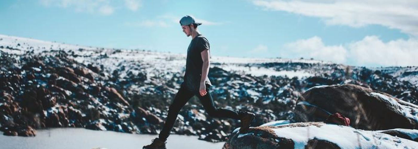 Young man stepping on the cliff's edge