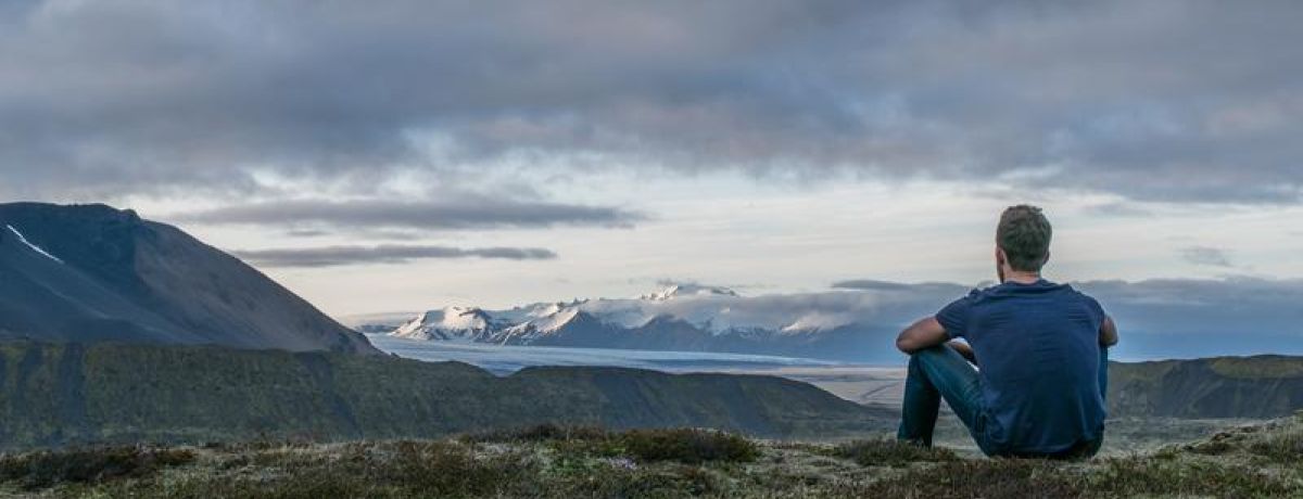 Man looking out to horizon mountains