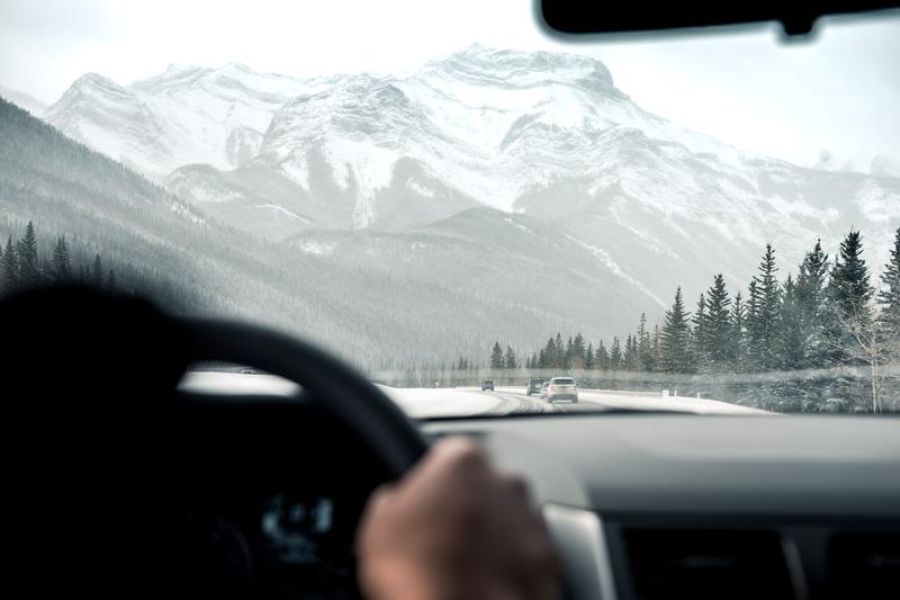 Driving in car toward winter mountain