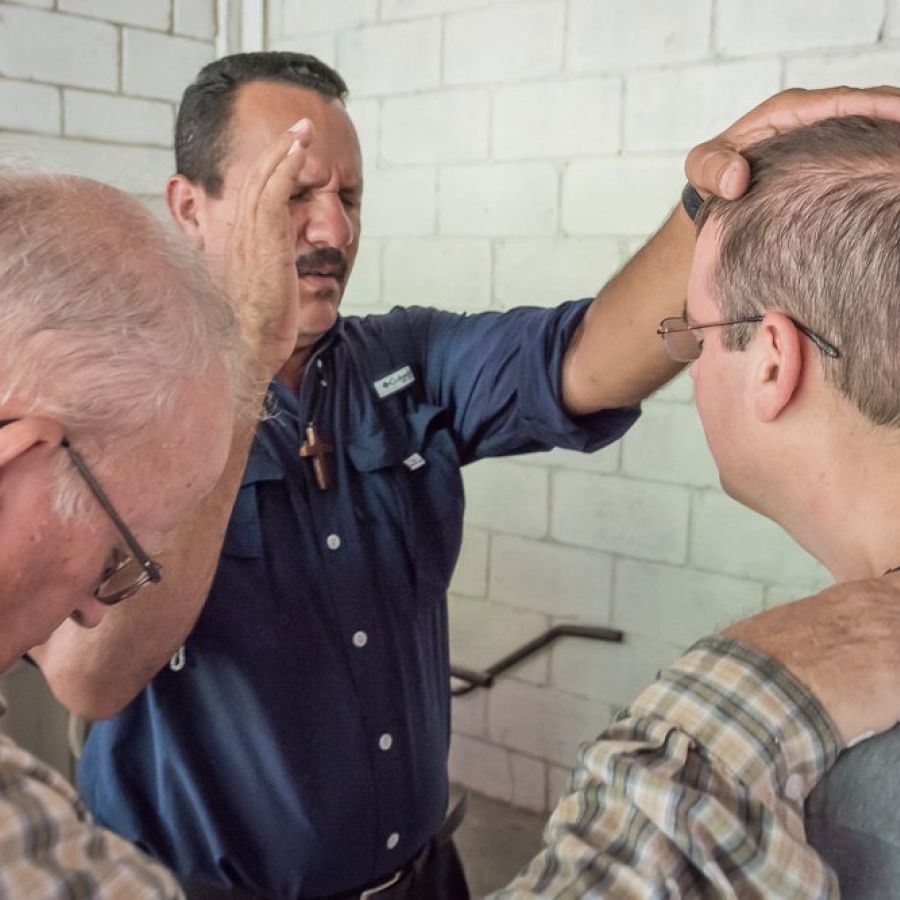 men praying for someone