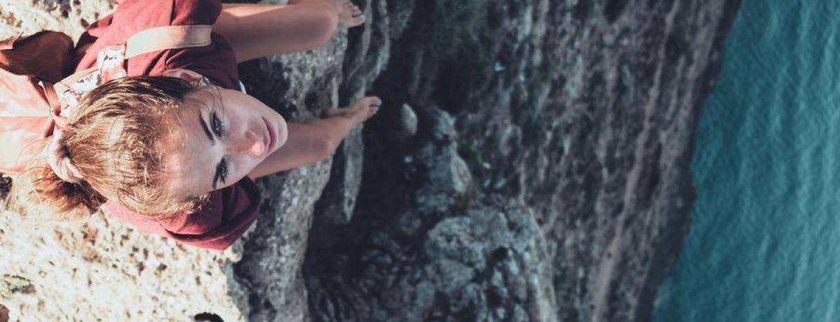 Girl Sitting On The Edge Of A Cliff Water