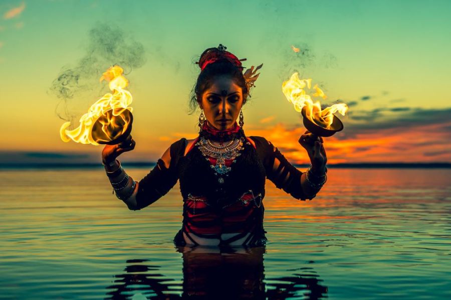 woman wiht fire cups in the water, outdoors