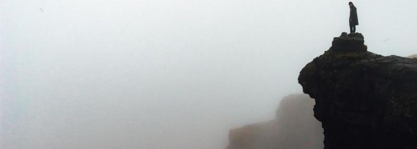 looking out to the horizon over a foggy cliff