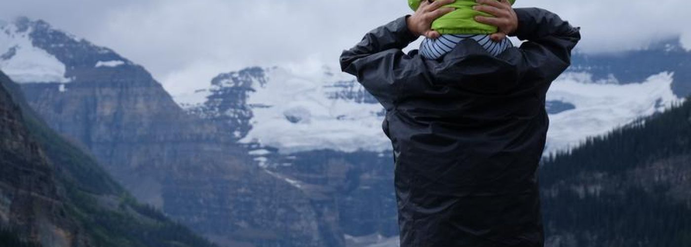 baby on shoulders looking at mountain