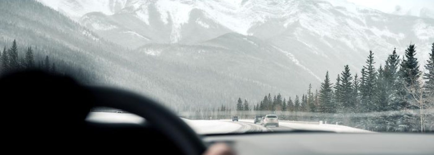 Driving in car toward winter mountain