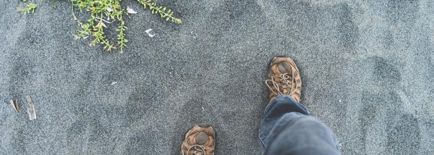 Steps onto sand, feet view