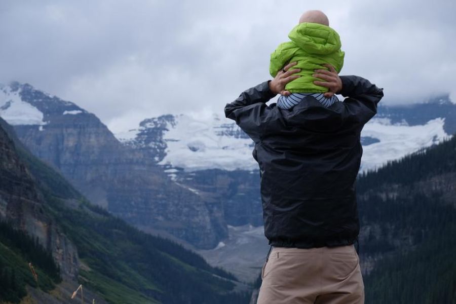 baby on shoulders looking at mountain