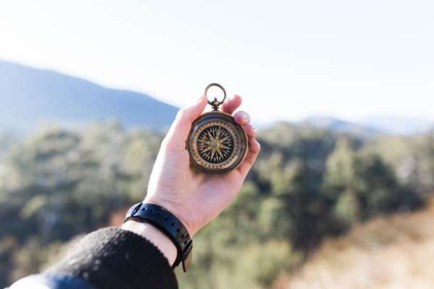 person holding a compass outdoors