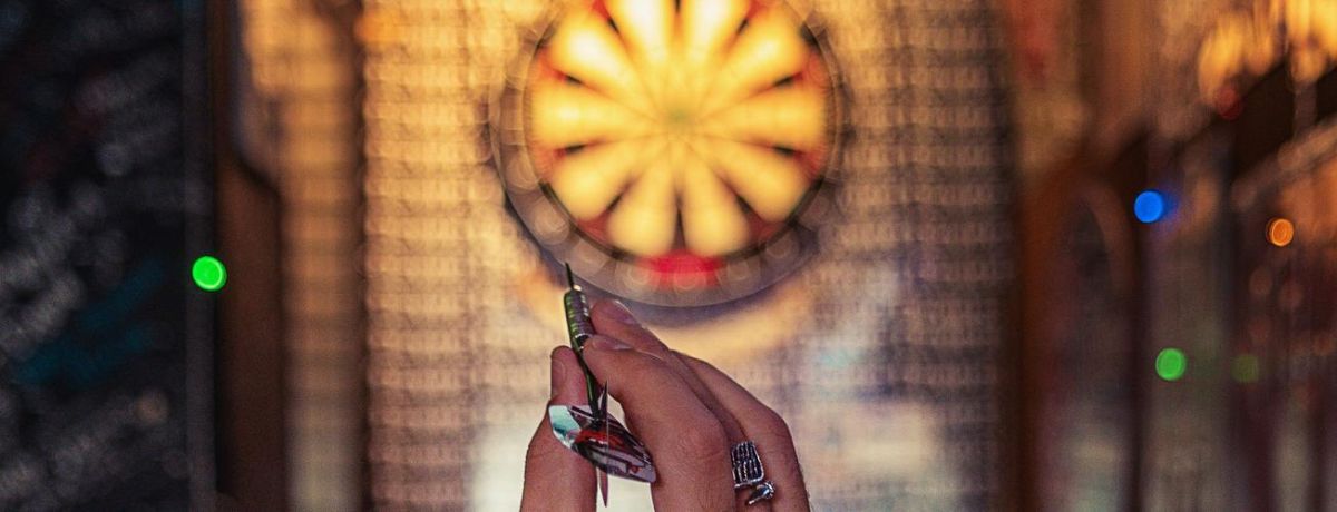 person preparing to throw a dart at the target