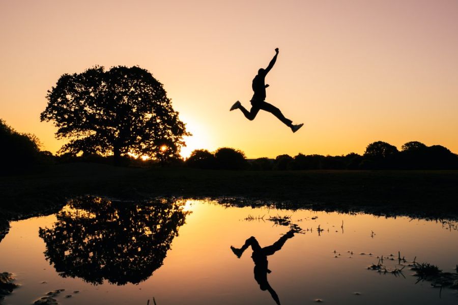 man jumping high across water