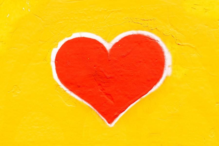 red painted heart on a yellow wall