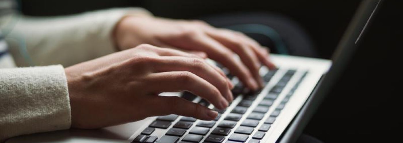 hands typing on a computer