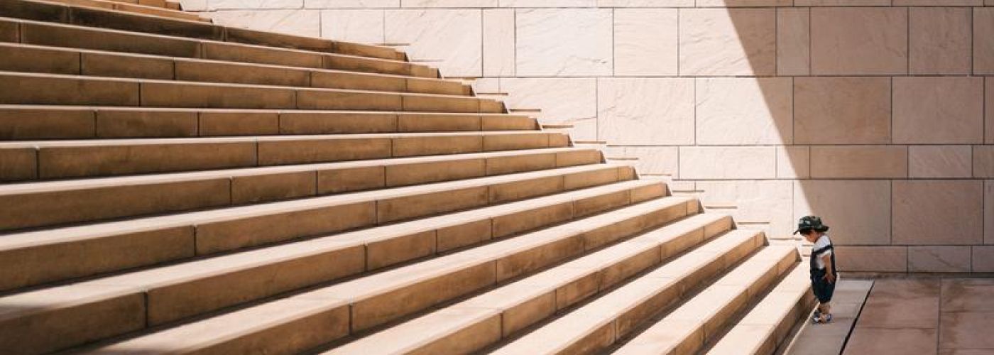 kid looking up stairs about to start climbing